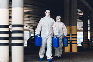 Covid-19, coronavirus, quarantine, medical workers in protective suits carrying barrels with disinfectant